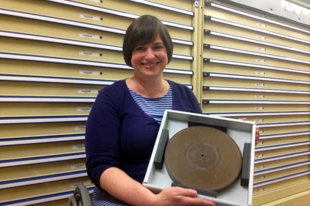 NFSA Sound Archivist Tamara Osicka with a brown wax recording disc made by Stuart Booty.