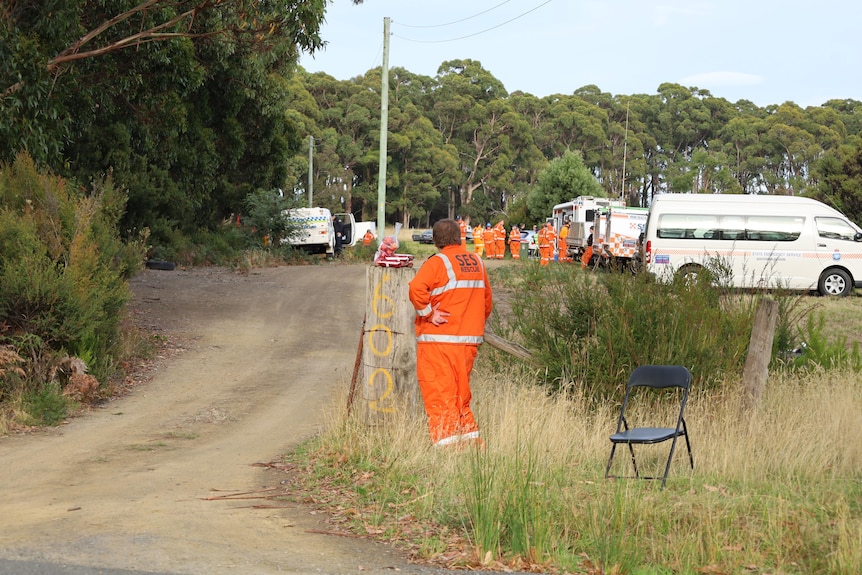 An SES member looks on at parked search cars.