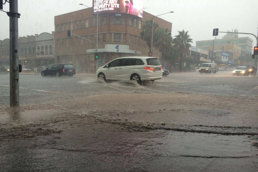 Cars drive through a flooded intersection on the corner of Ryrie and Moorabool streets in Geelong.