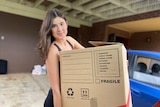 a woman holding a moving box