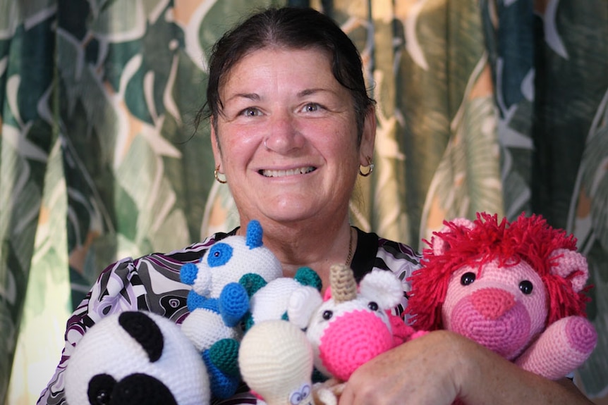 Maz Gough holds an armful of crocheted toy animals