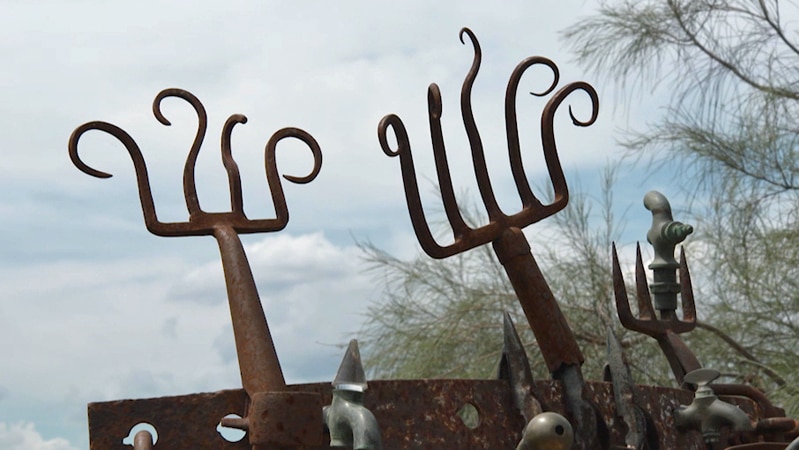 Garden ornament made from rusted garden forks with tines bent and curled over