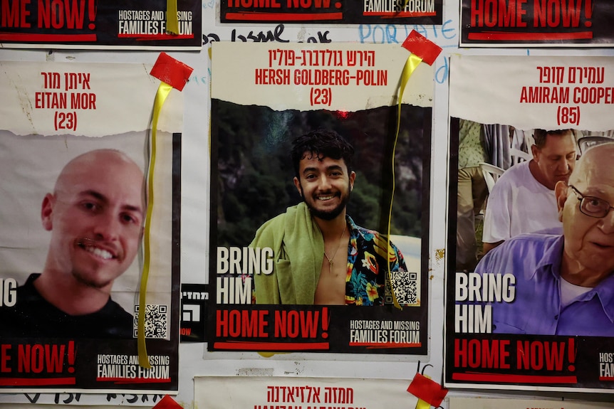 Posters of three men the middle is Hersh Goldberg-Polin with the words bring him home now.