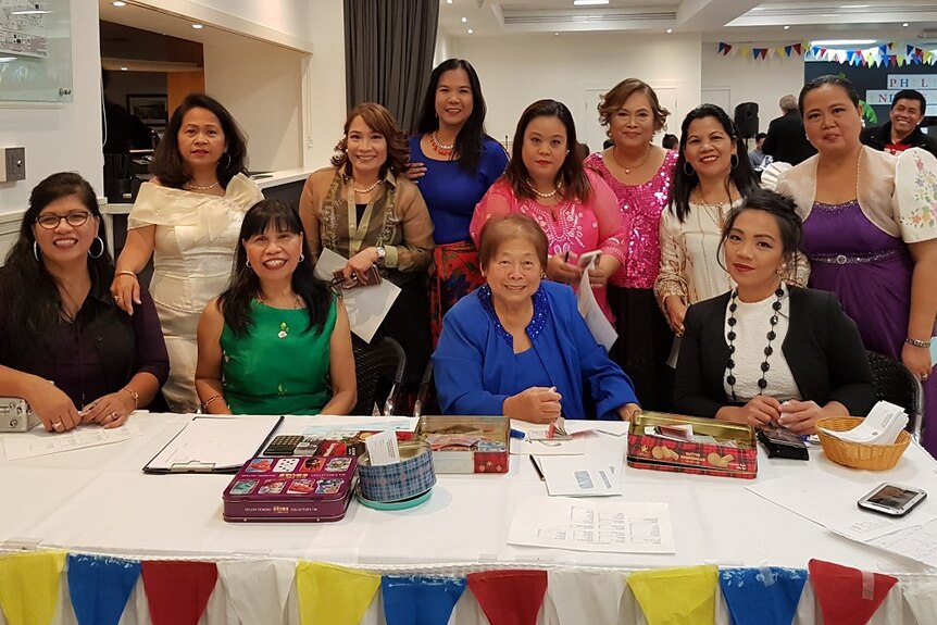 A group of Filipino women dressed for a celebration, smiling.