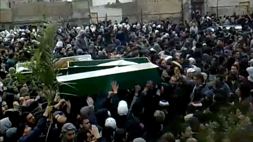 Syrian mourners carry coffins of demonstrators during a mass funeral in Damascus.