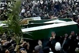 Syrian mourners carry coffins of demonstrators during a mass funeral in Damascus.