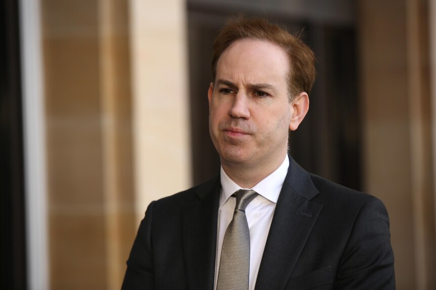 Warren Pearce wears a suit and tie outside WA parliament