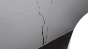 A wide crack low on the interior wall of a house