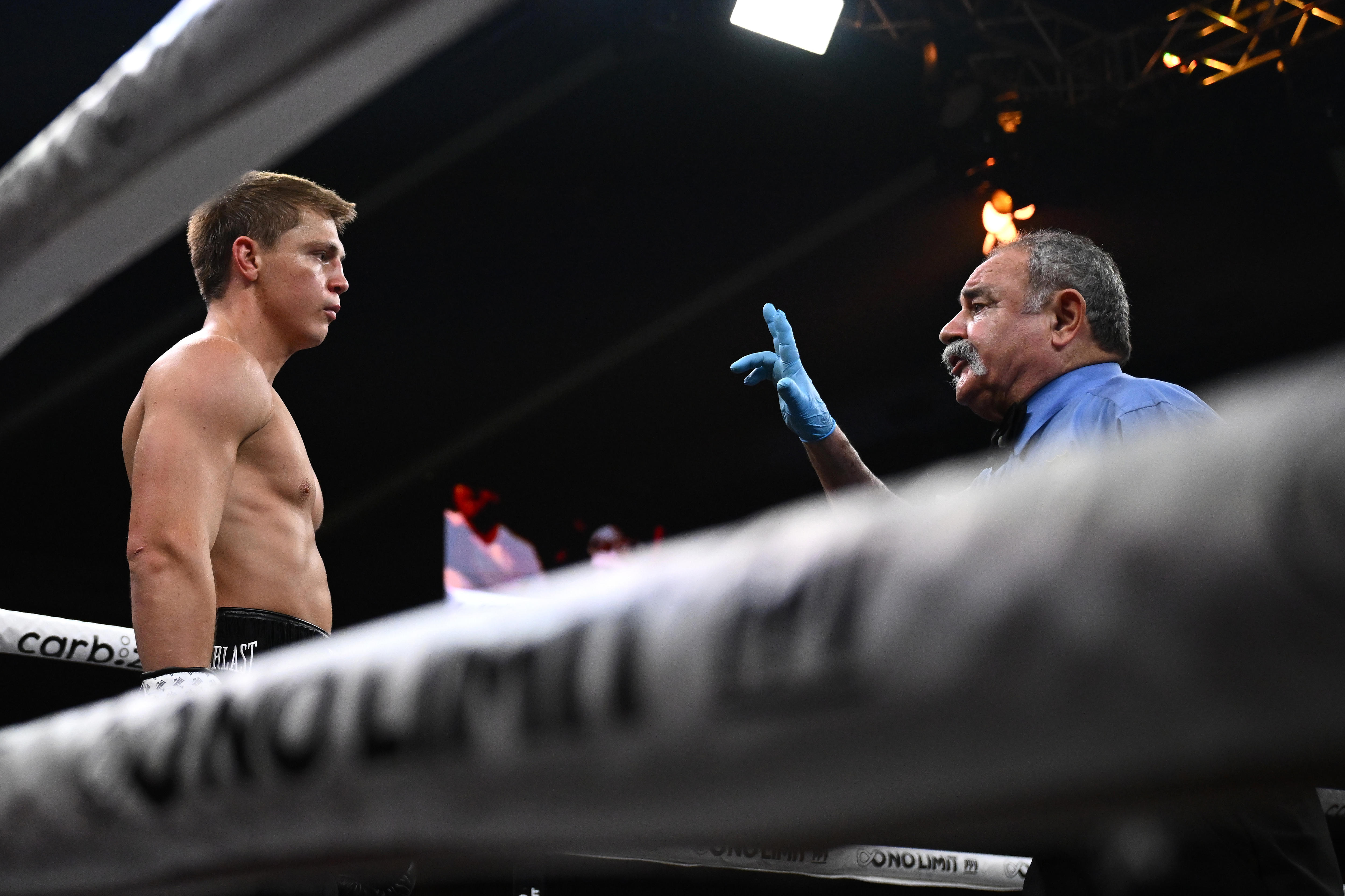 A boxing referee holds up his fingers to Nikita Tszyu during a fight.