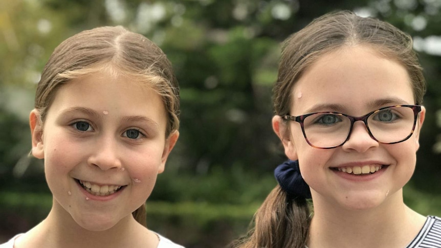 Two young girls with spots on their faces from chickenpox