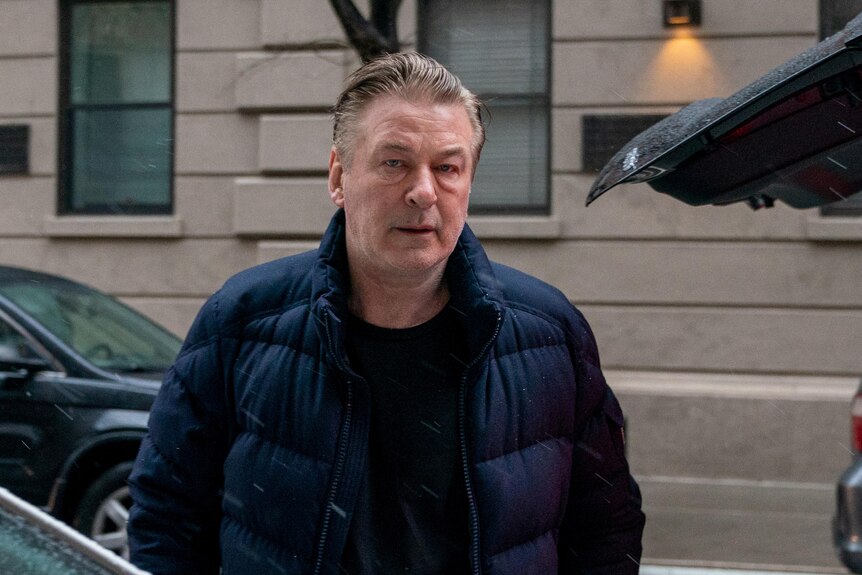 Alec Baldwin in a puffer jacket looking stressed. 
