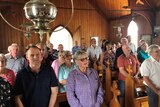 A church crowded with people singing
