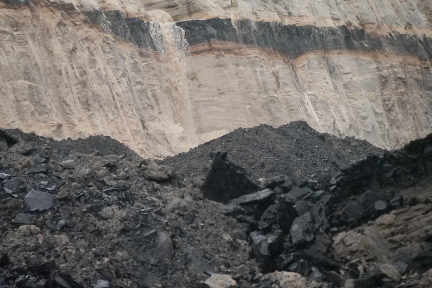 A coal seam behind a pile of coal