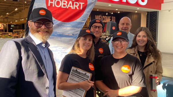 ABC Radio Hobart Mornings team standing smiling together at live broadcast