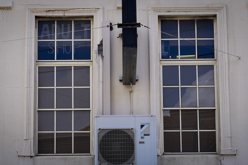 An adult shop on the second floor of a building in suburban Sydney is advertised with a nondescript sign in the window.