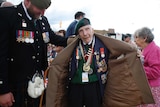 British D-Day veteran Harry Billinge opens his coat to show his medals.