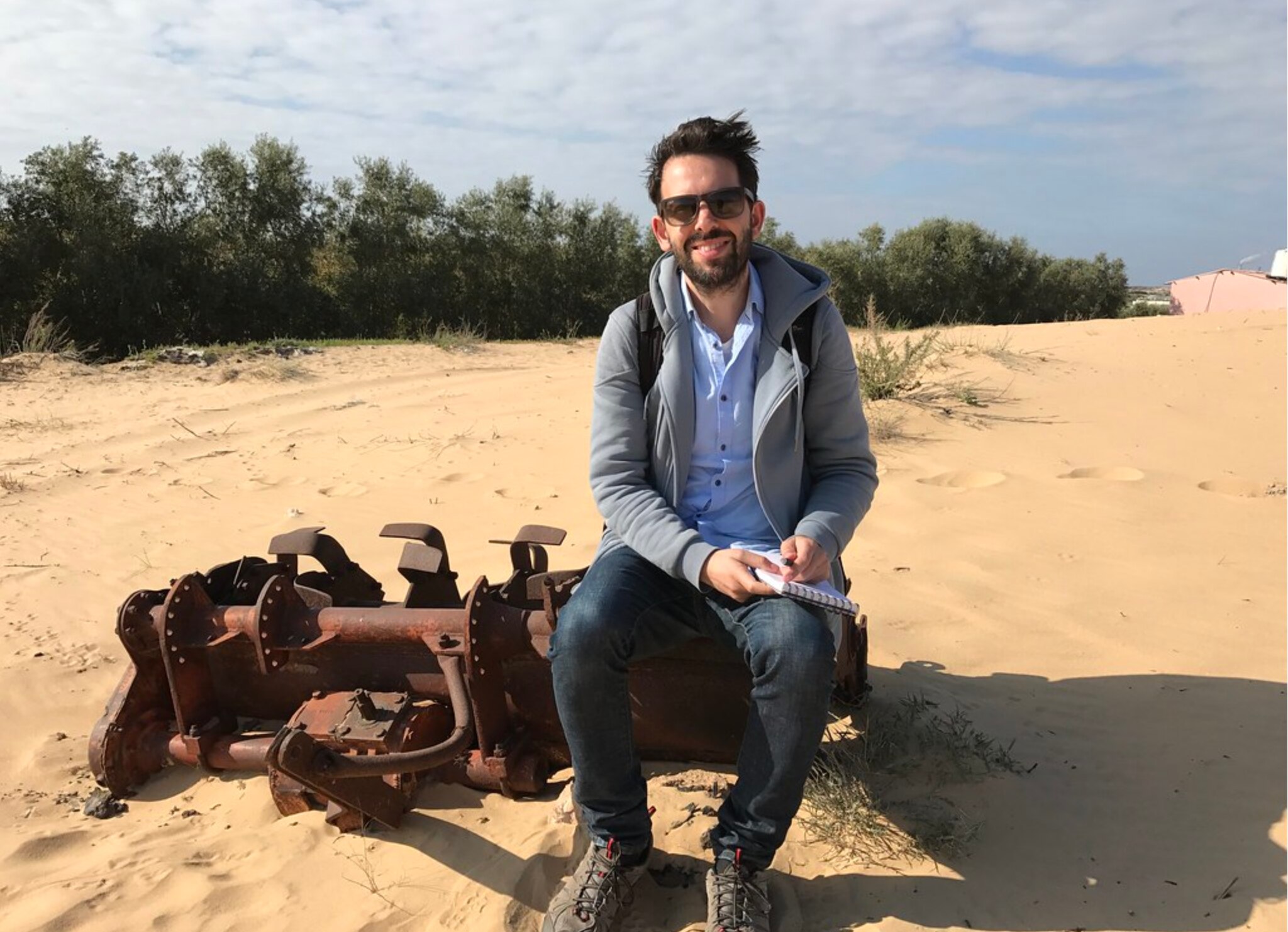Antony Loewenstein sits on some machinery in Gaza before the war 