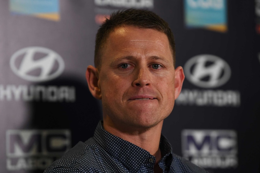 Brendon Bolton, with tears in his eyes, looks to a reporter as he awaits a question at a media conference.