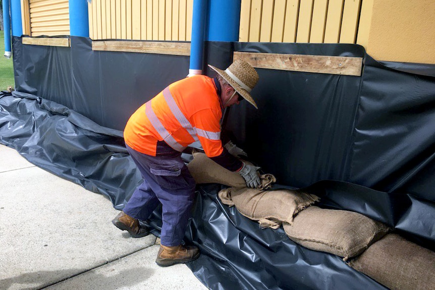 A council worker sandbags a restaurant in Townsville