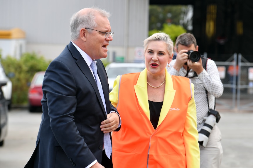 Australian Prime Minister Scott Morrison stands in a car park next to Liberal senator Hollie Hughes, who wears a high-viz vest
