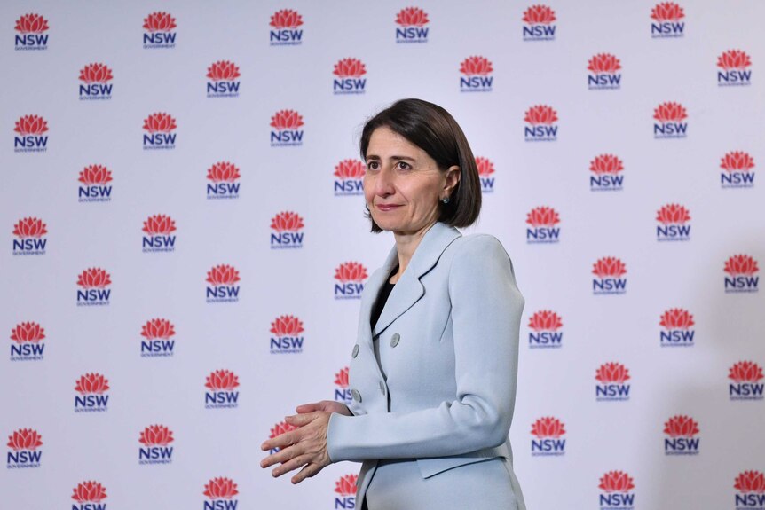 A woman with brown hair against a NSW government backdrop