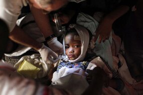 An injured child receives medical treatment in Haiti (Reuters: Eduardo Munoz)
