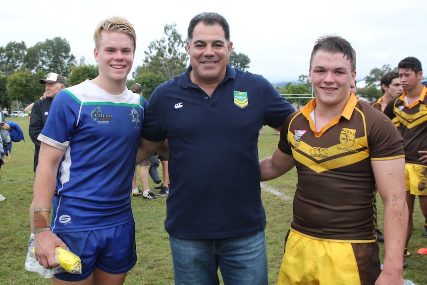 Rugby league coach Mal Meninga presenting awards to two high school rugby league players