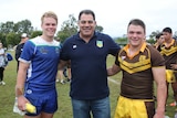 Rugby league coach Mal Meninga presenting awards to two high school rugby league players