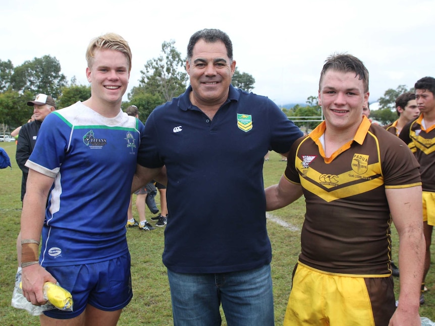 Rugby league coach Mal Meninga presenting awards to two high school rugby league players