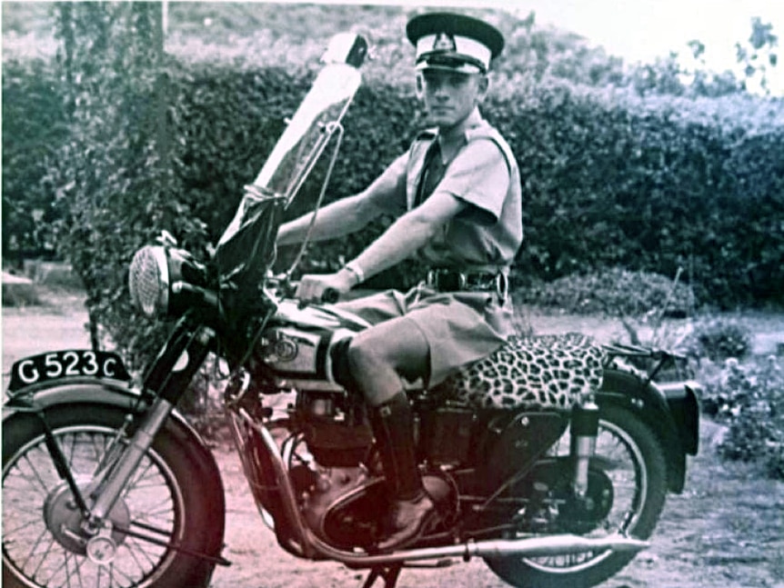 black and white photo featuring man on motorbike 