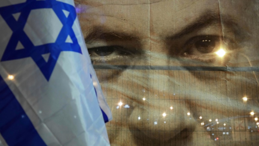 A banner depicts Israeli Prime Minister Benjamin Netanyahu next to an Israeli flag during a protest.