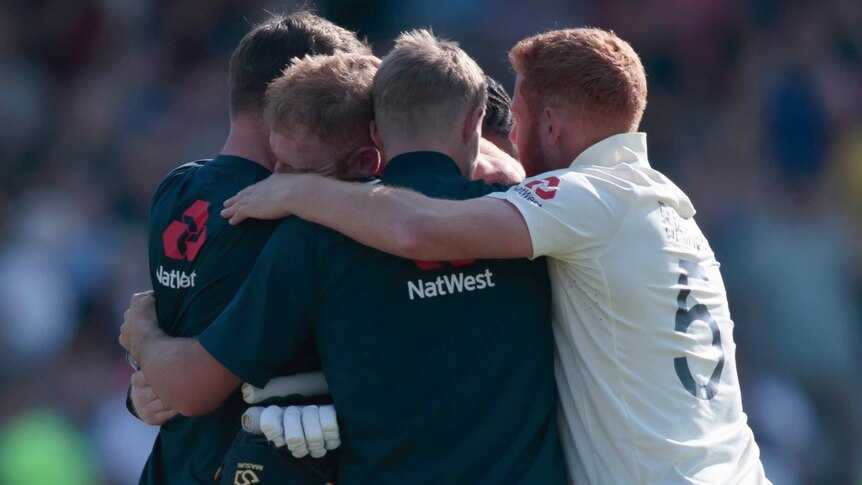 A group of cricketers huddle in celebration after winning a dramatic Ashes Test.