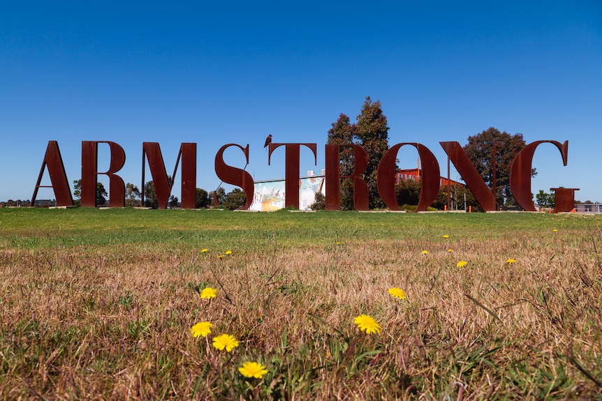 Large metal letters spelling out Armstrong on a blue sky day. 