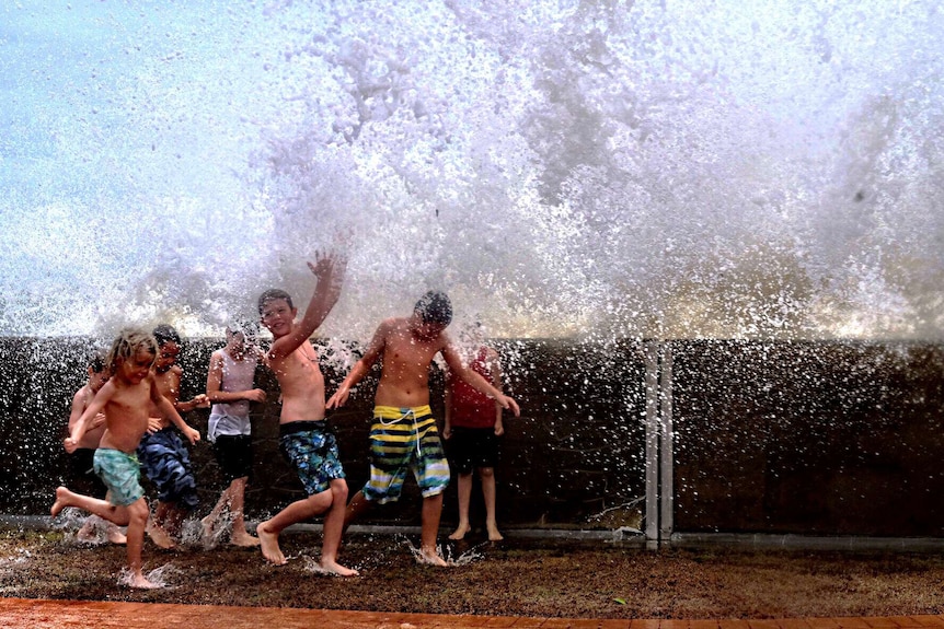 Children play in the waves at Hervey Bay following Cyclone Marcia