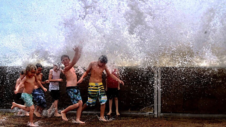 Children play in the waves at Hervey Bay following Cyclone Marcia