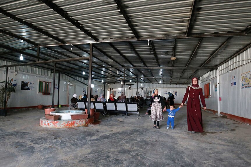 Women walk through the hangar-like waiting room for the Zaatari refugee camp, May 2017.