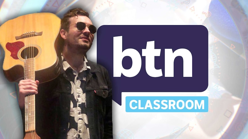 Reporter Matthew Holbrook poses with an acoustic guitar in front of the BTN logo