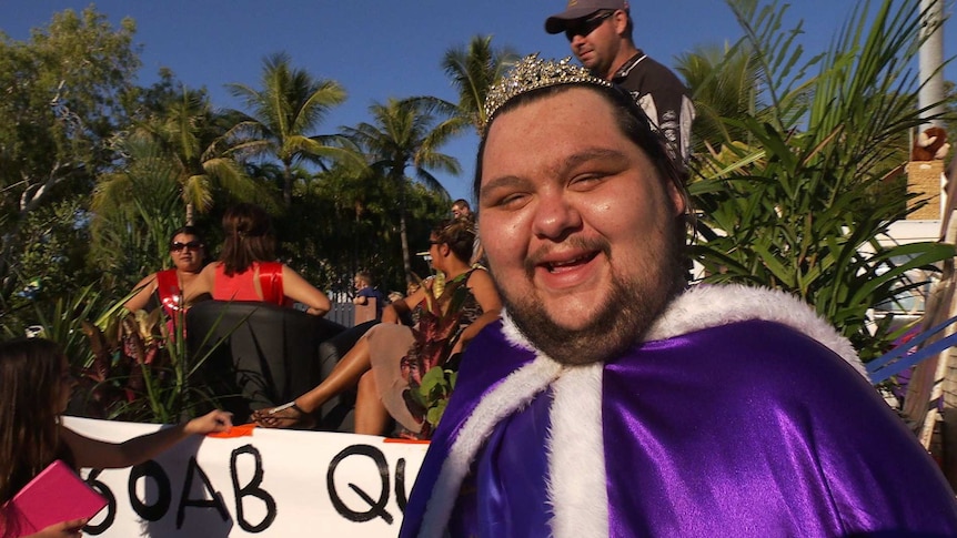 Trent Ozies wearing his crown and purple cape on the Mardi Gras float