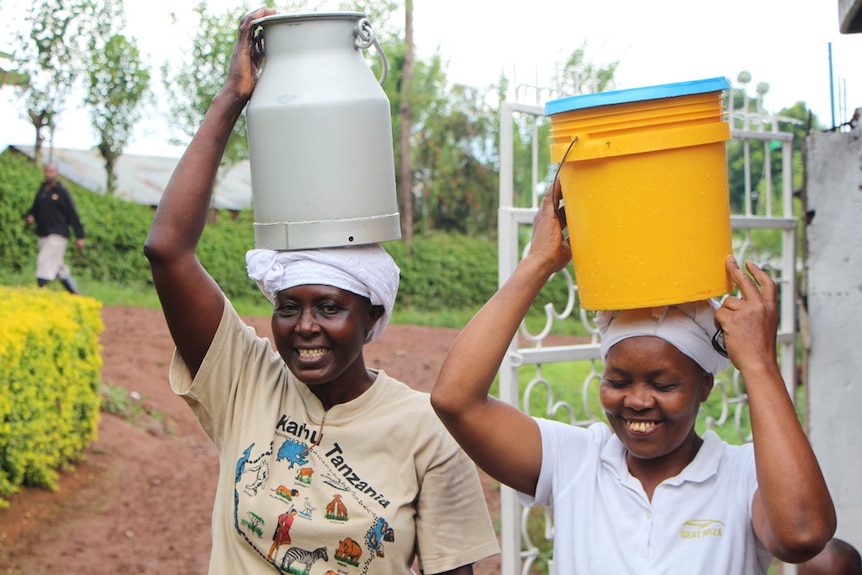 Women carrying containers of milk