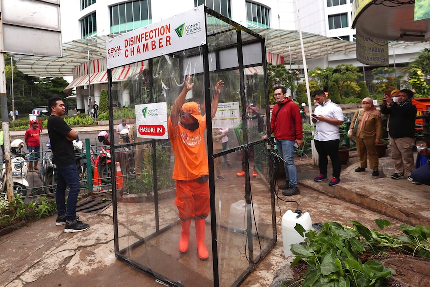 A man stands inside a makeshift sterilisation chamber in Jakarta, Indonesia