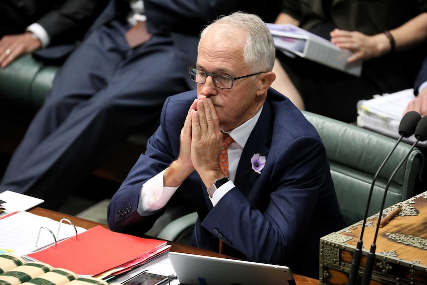Malcolm Turnbull sits in the House of Representatives, his hands clasped before him.