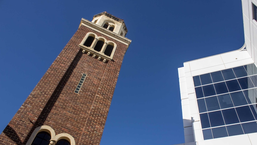 The Romanesque Loreto bell tower contrasts with the stark white design of the tax office building.