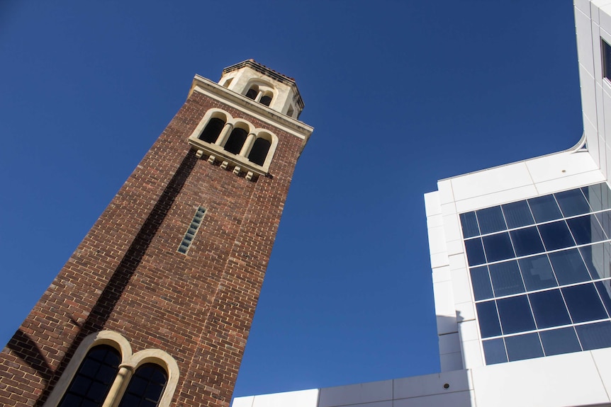 The Romanesque Loreto bell tower contrasts with the stark white design of the tax office building.