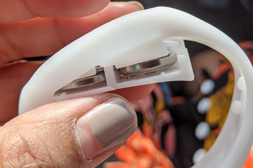 Hand holds a wristband with button batteries given out at AFL Grand Final in Brisbane