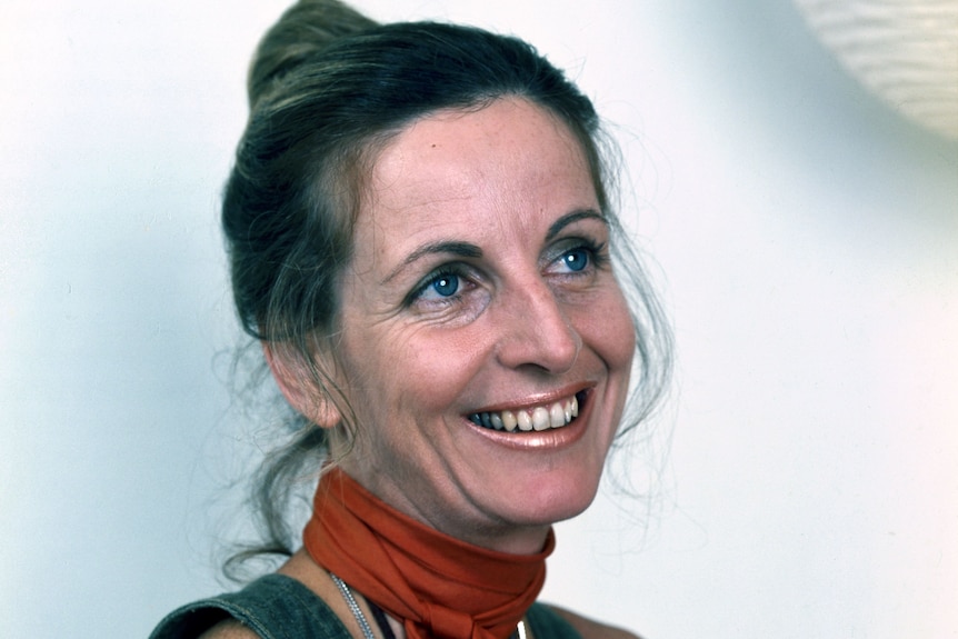 A young Caroline Jones smiles in a portrait wearing a red scarf around her neck
