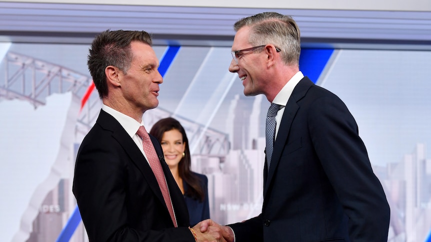 Chris Minns and Dominic Perrotet shake hands in a TV studio after an election debate.