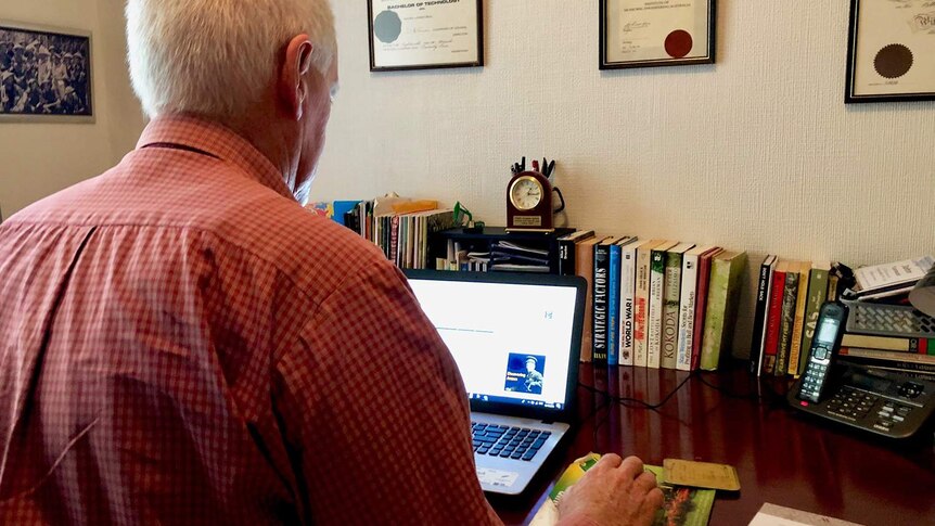 John Tannock, an avocado farmer near Ravensbourne on Queensland's Darling Downs, sits in front of a computer in his house.