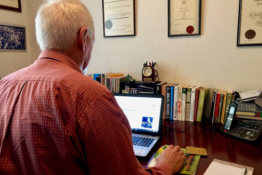 John Tannock, an avocado farmer near Ravensbourne on Queensland's Darling Downs, sits in front of a computer in his house.