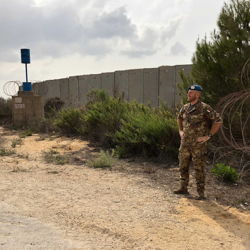 A guard stands at the Blue Line wall