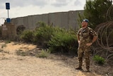 A guard stands at the Blue Line wall